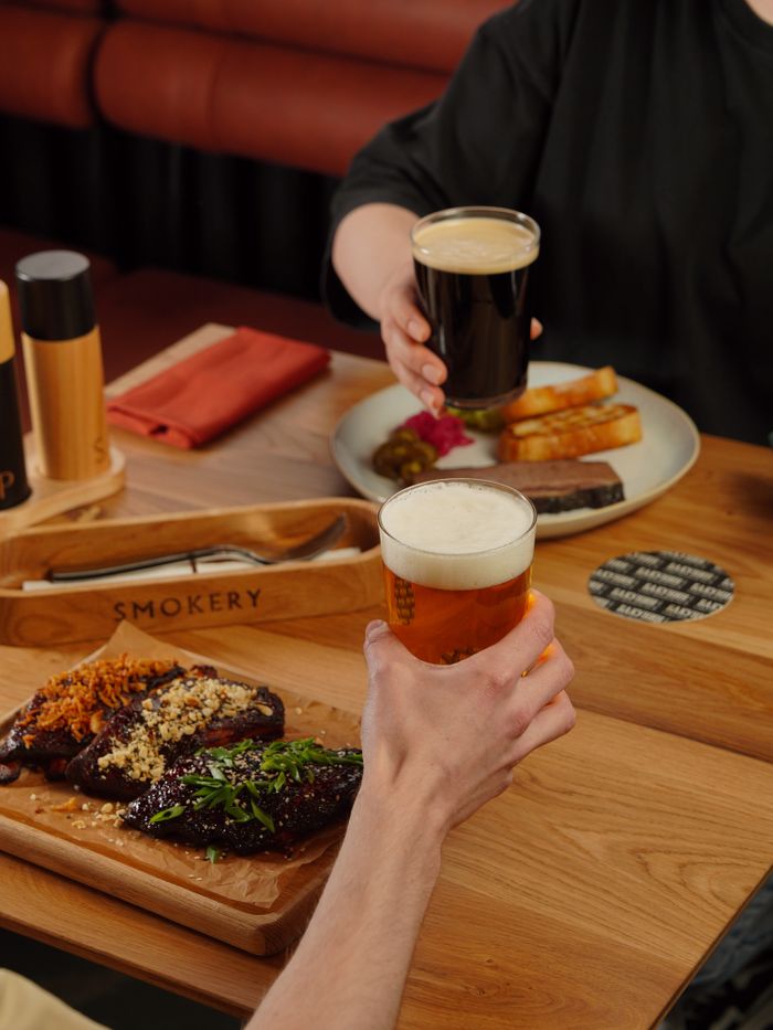 Savory BBQ ribs with craft beers in a cozy dining setting, perfect for food lovers.