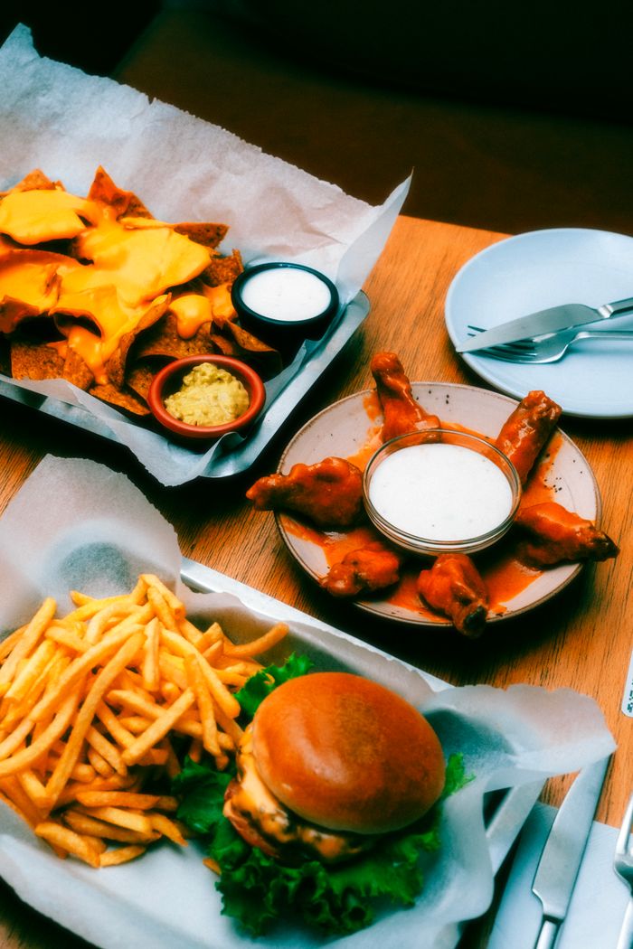 An inviting spread of classic American diner food including burgers, fries, and nachos captured from above.